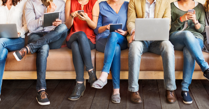 A team of people sit on a couch reading about Microlearning Benefits